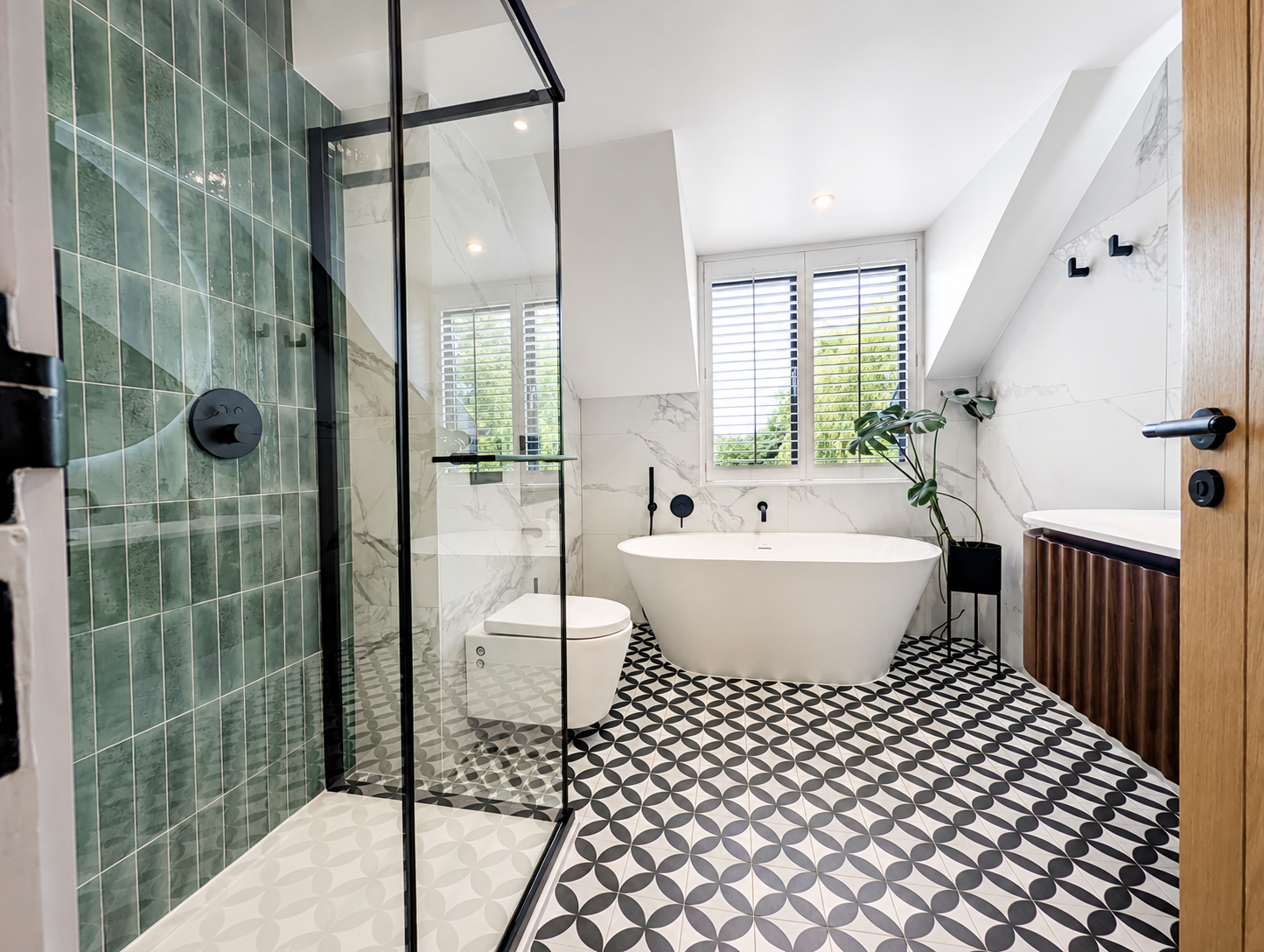 Contemporary bathroom with green metro tiles, freestanding bath and patterned floor