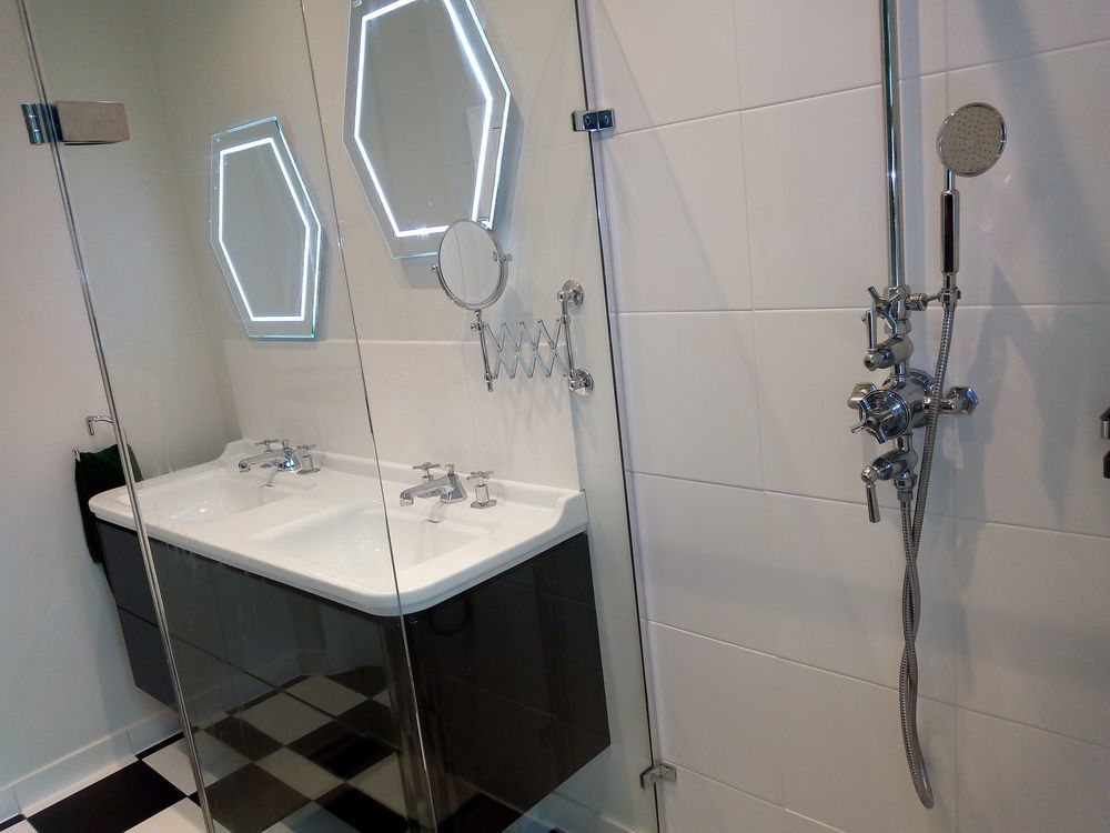 Walk-in shower with hexagonal LED mirrors and double vanity