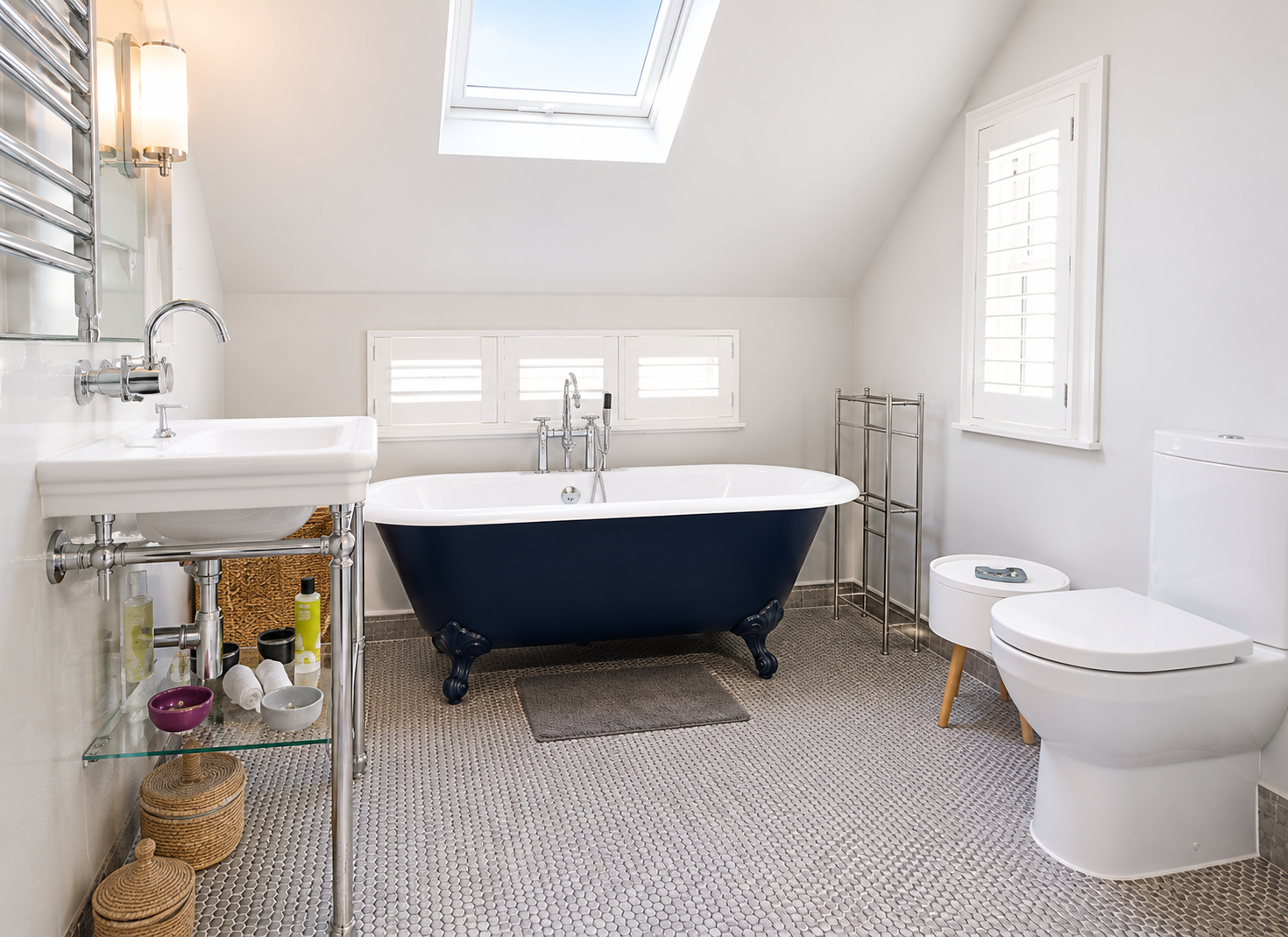 Classic bathroom with navy freestanding roll-top bath, herringbone wall tiles and skylight